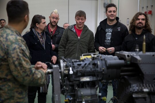 Members of the multi-platinum rock group, 3 Doors Down, observe some of the equipment the Marines at Marine Aviation Logistics Squadron 12 work with on a daily basis during their visit at Marine Corps Air Station Iwakuni, Japan, Jan. 14, 2016. Members of the band said they do these tours in order to give back to the men and women who have already given so much.