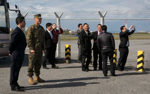 Col. Peter Lee, second from left, escorts members of the Liberal Democratic Party Youth Bureau of Gunma Prefecture to the flight line Jan. 25 on Marine Corps Air Station Futenma, Okinawa, Japan. During the visit, Lee explained the logistics and capabilities of the MCAS Futenma followed by a tour of the flight line. The members had the opportunity to witness an MV-22B Osprey landing on the flight line, and step off their tour bus to take photos. Lee is the commanding officer of MCAS Futenma.