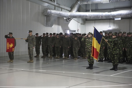 Marines with 3rd Battalion, 8th Marines salute alongside members of the Romanian Armed Forces during the transfer-of-authority ceremony aboard Mihail Kognalniceanu Air Base, Romania, Jan. 22, 2016. The rotational force of Marines and sailors gives U.S. European Command the continuous capability to integrate with NATO and partner nations in Eastern Europe. (U.S. Marine Corps photo by Cpl. Immanuel M. Johnson/Released)