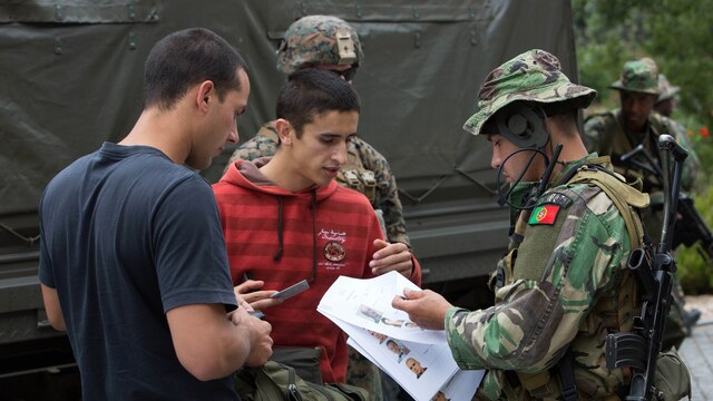 A Portuguese soldier verifies the identities of two simulated refugees at an evacuation collection point during Exercise Orion 16 in Santa Margarida, Portugal, June 23, 2016. This training gave the Marines an opportunity to work side by side the Portuguese military, providing invaluable experience for future joint operations. 