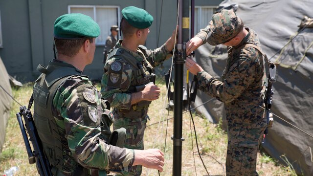 U.S. Marine Corps Lance Cpl. Colby Goranson, a radio operator with Special Purpose Marine Air-Ground Task Force-Crisis Response-Africa, works with Portuguese soldiers to set up communications equipment during Exercise Orion 16 at military training area Tancos, Portugal, June 22, 2016.