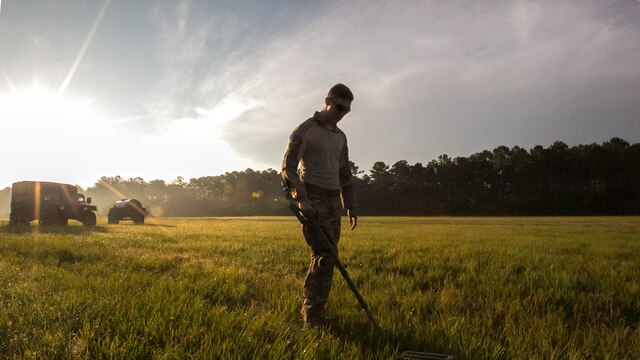 Senior Airman Christian Hulsey, an explosive ordnance technician with 4th civil engineer squadron, sweeps the ground for unexploded ordnance during a field exercise at Marine Corps Base Camp Lejeune, N.C., June 30, 2016. The field exercise was a weeklong event in which Marines and airmen trained together to enhance their skills as EOD technicians. 