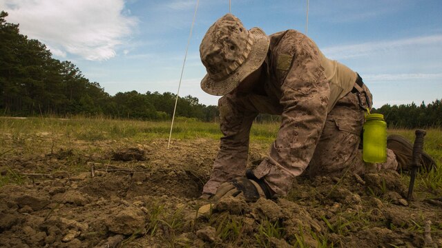 A Marine with 2nd Explosive Ordnance Disposal Company unearths a 155mm mortar round during a field training exercise at Marine Corps Base Camp Lejeune, N.C., June 30, 2016. The exercise consisted of multiple tasks that an EOD technician might face while deployed, which tested their abilities to safely find, evaluate and dispose of unexploded ordnance.