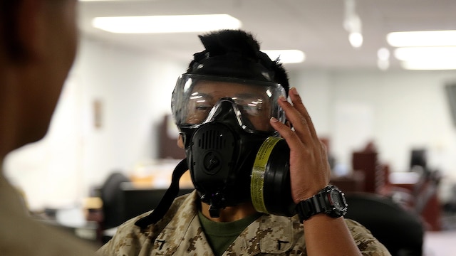 Pfc. Amethyst Bou, an administrative specialist with H&S company for Chemical Biological Incident Response Force, CBIRF, Marine Corps Forces Command, inspects his M53 gas mask for a proper seal, during gas mask drills on June 7. The Gas Mask Drill was to ensure all the Marines and Sailors are proficient to meet the nine second limit to successfully put on a gas mask in case of any real threat. The drill is necessary to ensure CBIRF’s ability to be ready at any moment’s notice.