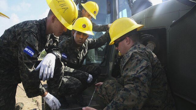 Corporal Kaleb R. Hougland, senior heavy equipment mechanic, conducts a period of instruction on the maintenance of a Caterpillar D6K Bulldozer at Puerto Castilla, Honduras, June 24, 2016. The Marines worked side-by-side on different construction and restoration projects, and shared knowledge and experience on techniques including maintenance and operation of heavy equipment.