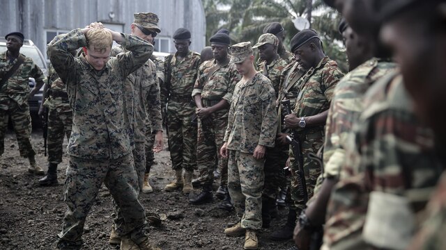 Lance Cpl. Christopher Parsons, and Lance Cpl. Dustin Kitts, riflemen with Special Purpose Marine Air-Ground Task Force Crisis Response-Africa, shows Cameroonian soldiers with Forces Fusiliers Marins et Palmeurs de Combat how to conduct personnel searches in Limbé, Cameroon, June 30, 2016. Marines share tactics, techniques and skills with the FORFUMAPCO soldiers to combat the illicit trafficking in Cameroon. 
