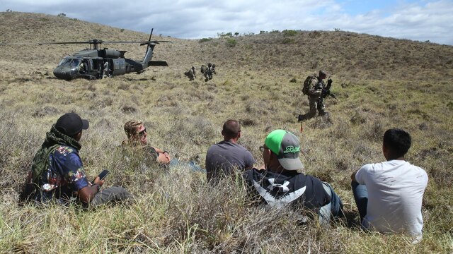 Marines wait for simulated aid during a humanitarian exercise at an improvised landing zone near the Pohakuloa Training Area, Hawaii, July 9, 2016, during Rim of the Pacific 2016. Twenty-six nations, 49 ships, six submarines, about 200 aircraft, and 25,000 personnel are participating in RIMPAC 2016 from June 29 to Aug. 4 in and around the Hawaiian Islands and Southern California. The world’s largest international maritime exercise, RIMPAC provides a unique training opportunity while fostering and sustaining cooperative relationships between participants critical to ensuring the safety of sea lanes and security on the world’s oceans. RIMPAC 16 is the 25th exercise in the series that began in 1971.