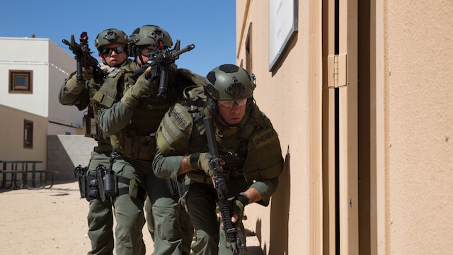 Deputy sheriffs with the San Bernardino County Sheriff’s Department Special Weapons and Tactics Team prepare to enter a building in the military operations in urban terrain facility at Range 800 aboard Marine Corps Air Ground Combat Center Twentynine Palms Calif., July 12, 2016. The Combat Center’s Special Reaction Team hosted the cross-training to provide SBCSD with insight of the Marine Corps’ tactics capabilities. 