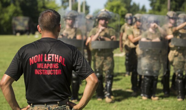 A non-lethal weapons instructor with 2nd Law Enforcement Battalion, watches Marines with 3rd Battalion, 2nd Marine Regiment practice riot control formations and tactics during a non-lethal weapons course aboard Camp Lejeune, North Carolina, July 15, 2016. Throughout the course they learned about various take-down techniques utilizing a police baton, riot control formations and tactics as well as the function and result of using a taser.