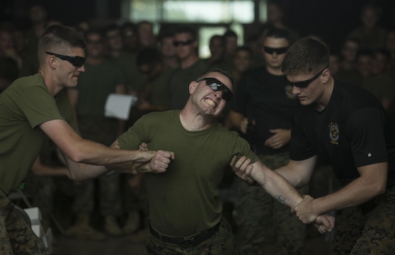 Marines with 3rd Battalion, 2nd Marine Regiment tenses up when struck with the tasers barbs during a non-lethal weapons course aboard Camp Lejeune, North Carolina, July 15, 2016. Throughout the course they learned about various take-down techniques utilizing a police baton, riot control formations and tactics as well as the function and result of using a taser.