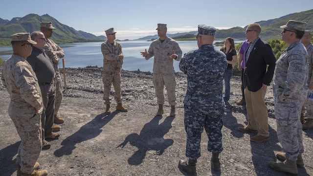 Gunnery Sgt. Brandon Watson (center), project coordinator for Innovative Readiness Training Old Harbor, Alaska, briefs a group of distinguished visitors from different military branches and civilian agencies July 11, 2016.