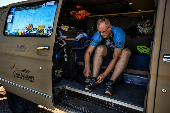 Staff Sgt. Kyle Emmel, a 17th Training Group student, fastens his cycling shoes before a ride in San Angelo, Texas, July 19, 2016. Emmel customized the interior of his van so he could take his bike everywhere he goes. The van is divided into two sections, including a small living area and a trunk used for bike storage. (U.S. Air Force photo/Senior Airman Devin Boyer)