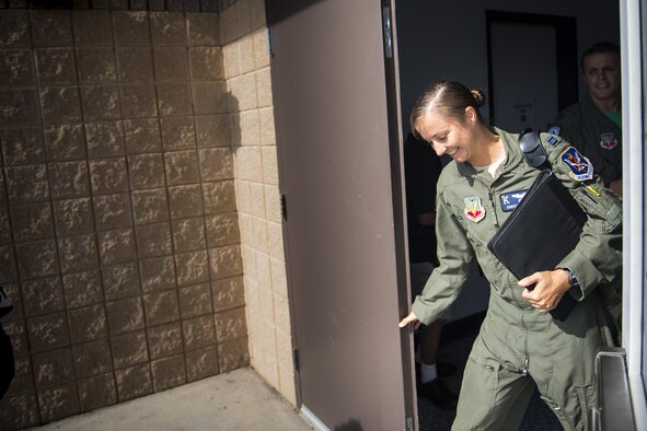 U.S. Air Force Capt. Christy Wise, 71st Rescue Squadron pilot, steps through the rear door of the 71st RQS building to begin her walk to the flightline for her first flight since becoming an above-the-knee amputee, July 22, 2016, at Moody Air Force Base, Ga. Wise became an amputee after a boating accident in April of 2015. (U.S. Air Force Photo by Senior Airman Ryan Callaghan)
