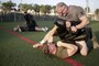 Chef Robert Irvine wrestles with Marine Cpl. Matthew Heldt during a physical training event at Naval Air Station Sigonella, Italy, July 28, 2016. Marines completed a circuit course with the celebrity chef, which included upper and lower body workouts and laps. Marine Corps photo by Cpl. Alexander Mitchell
