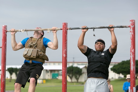 Lance Cpl. Samuel St. Clair, left, and Sgt. Geirrell Grayer perform pullups while participating in the “Murph” Challenge for Memorial Day on Marine Corps Air Station Futenma, Okinawa, Japan. The “Murph” Challenge is a workout made to honor Lt. Michael “Murph” Murphy, a navy SEAL who died in Afghanistan June 28, 2005, at the age of 29. The challenge consists of a one-mile run, 100 pullups, 200 pushups, 300 squats, and another one-mile run, while wearing a 20 pound vest. St. Clair is a financial management resource analyst with Headquarters and Headquarters Squadron, MCAS Futenma, Marine Corps Installations Pacific. Grayer is a distribution management specialist with Headquarters and Support Battalion, Marine Corps Installations Pacific-Marine Corps Base Camp Butler, Japan. (Marine Corps Photo by Cpl. Douglas Simons/Released)