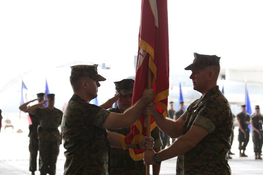 Lt. Col. Matthew W. Stover, commanding officer of Marine Aerial Refueler Transport Squadron (VMGR) 152, passes the colors to Lt. Col. Andrew J. Pushart, Marine Aircraft Group 12 special projects officer, during a change of command ceremony at Marine Corps Air Station Iwakuni, Japan, May 27, 2016. The passing of the colors signifies the passing of command from one commanding officer to another. This marks Pushart's third tour with VMGR-152. (U.S. Marine Corps photo by Cpl. Nicole Zurbrugg/Released)