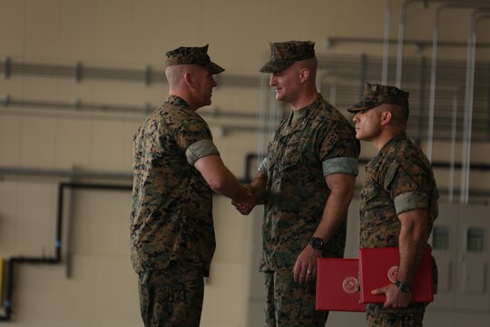 Col. Daniel Shipley, commanding officer of Marine Aircraft Group (MAG) 12, congratulates Lt. Col. Matthew W. Stover, commanding officer of Marine Aerial Refueler Transport Squadron (VMGR) 152, on a successful tour of commanding officer during a change of command ceremony at Marine Corps Air Station Iwakuni, Japan, May 27, 2016. Stover served as the VMGR-152 commanding officer for two years and successfully transition the squadron from Okinawa to Iwakuni in 2014. (U.S. Marine Corps photo by Cpl. Nicole Zurbrugg/Released)