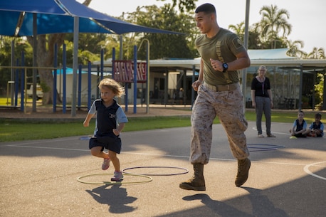 Lance Cpl. Adrian Lozano runs with a student during physical education at Larrakeyah Primary School, Northern Territory, Australia, on June 2, 2016. Marines with the Forward Coordination Element, Marine Rotational Force – Darwin, volunteered to help with classes at the school. Lozano, from Los Angeles, California, is an administration specialist with FCE, MRF-D.