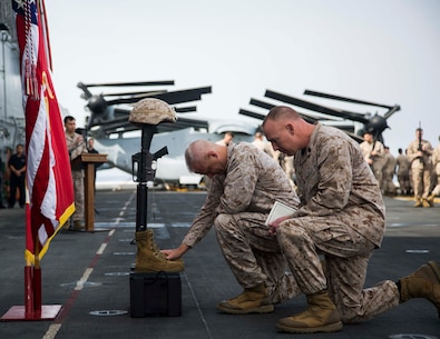 U.S. Marines Col. Robert C. Fulford and Sgt. Maj. Brett C. Scheuer respectively, 26th Marine Expeditionary Unit (MEU) pay their respects to Staff Sgt. Louis F. Cardin during memorial ceremony aboard the amphibious assault ship USS Kearsarge (LHD 3) in the Red Sea, Mar. 24, 2016. Staff Sgt. Cardin died from wounds suffered following an indirect fire attack at Fire Base Bell in northern Iraq.  The 26th MEU is embarked on the Kearsarge Amphibious Ready Group and is deployed to maintain regional security in the U.S. 5th Fleet area of operations. (U.S Marine Corps photo by Cpl. Jalen D. Phillips/Not Released/FOUO)