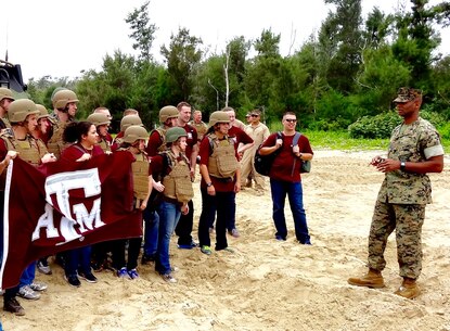 Battalion Commander Lt. Col. Carlos T. Jackson, right, addresses Texas A&M Corps of Cadets visitors on the Amphibious Assault Vehicle capability provided by Combat Assault Battalion in support of the 3rd Marine Division, May 18, 2016, at Camp Schwab, Okinawa, Japan. The Cadets visited Okinawa as part of a scholarship program which provides students the opportunity to tour military installations to learn about different occupational specialties and duty stations. This is the first time Texas A&M Corps of Cadets visited Okinawa.