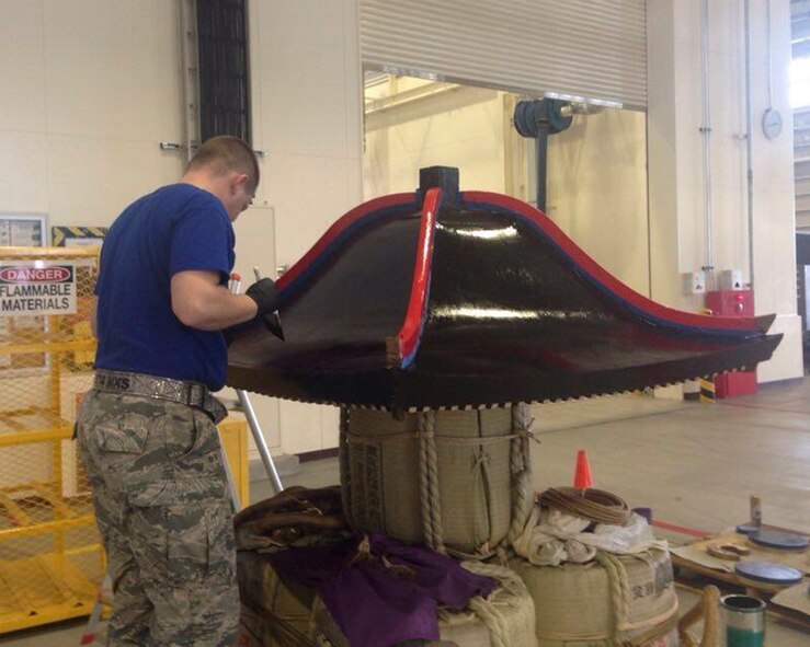 Tech. Sgt. Justin Williams, 374th Maintenance Squadron aerospace ground equipment NCO in charge, paints the Wing’s mikoshi at Yokota Air Base, Japan, Feb. 24, 2016. Airmen with the 374th MXS and 374th Maintenance Group worked over 150 hours to sand, strip, paint, and treat the wooden surfaces as well as trimming, shaping, and fitting over 10 square meters of brass to replace the ornate work over the course of one month. (Courtesy photo by 374th Maintenance Squadron AGE flight)