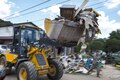 An airman directs a local responder operating a backhoe during flood cleanup in Elkview, W.Va., June 28, 2016. Air National Guard photo by Tech. Sgt. De-Juan Haley