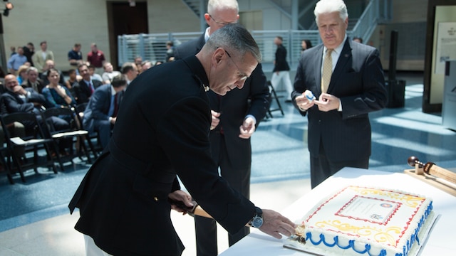 Brig. Gen. Christopher J. Mahoney, left, and Bill A. Miller cut a cake during the Diplomatic Security Service Centennial ceremony at the National Museum of the Marine Corps in Triangle, Virginia, June 29, 2016.