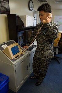 Japanese Air Self Defense Force Staff Sgt. Shinya Nishida speaks on an enhanced terminal voice switch while participating in the professional military exchange program February 23 in the base operations building on Marine Corps Air Station Futenma, Okinawa, Japan. The ETVS expedites calling and communication between air traffic control facilities. The professional military exchange program provided Nishida from the JASDF an opportunity to work with the Marine Corps to learn their job skills, culture and day-to-day life as a member of the U.S. armed services. Nishida is a flight plan dispatcher with the JASDF. (U.S. Marine Corps Photo by Cpl. Brittany A. James/Released)