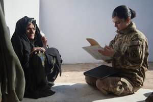 A U.S. Army Sergeant writes down information from a local woman at the Woman’s Center near the Zhari District Center, Kandahar province, Afghanistan.