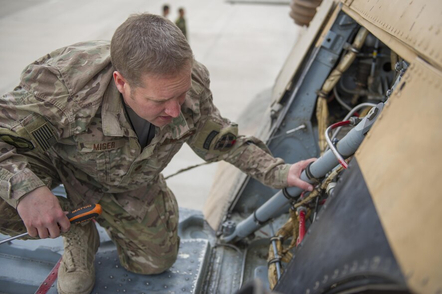 Maj. Jeffrey Miser, 441st Air Expeditionary Advisory Squadron commander, performs pre-flight checks on an Mi-17 helicopter owned by the Afghan Air Force prior to a training sortie at Kandahar Air Field, Afghanistan, March 3, 2016. TAAC-Air assists our Afghan partners to develop a professional, capable and sustainable force. (U.S. Air Force photo/Tech. Sgt. Robert Cloys)