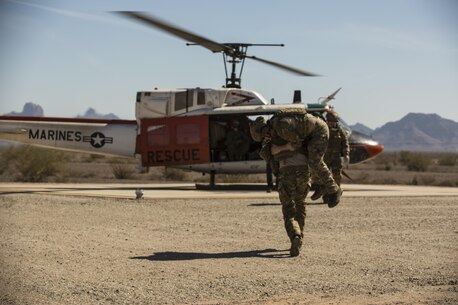 Marines with Search and Rescue, based out of Marine Corps Air Station Yuma, Ariz., wait as a casualty is rushed to their HH-1N “Huey” helicopter during simulated medical and casualty evacuations in support of the Special Operations Terminal Air Control Course at Yuma Proving Ground, Friday, March 4, 2016.