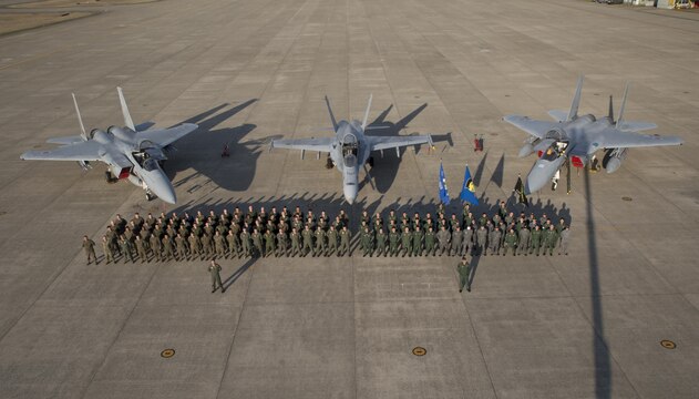 Members of Marine Fighter Attack Squadron (VMFA) 314 and Japan Air Self-Defense pose for a photo in front of an F/A-18AA++ and two F-15s at Komatsu Air Base, Japan, during the Komatsu Aviation Training Relocation exercise March 17, 2016. VMFA-314, home based out of Marine Corps Air Station Miramar, San Diego, temporarily deployed to MCAS Iwakuni for a six month rotation with the unit deployment program, is forward deployed to Komatsu, Japan for the ATR.  Komatsu ATR is a dissimilar air combat training exercise allowing pilots with diverse aircraft to simulate aerial warfare and execute basic fighter maneuvers, aircraft tactical intercepts and offensive-defensive counter air missions in preparation for real wartime situations. (U.S. Marine Corps photo by Cpl. Nicole Zurbrugg/Released)