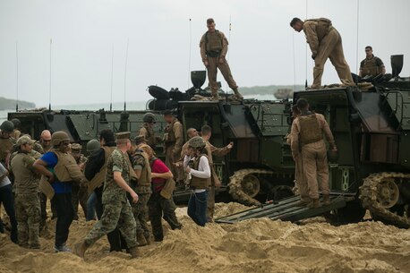 Marines and their family members put on flak jackets and Kevlar helmets, preparing to “splash” on an Amphibious Assault Vehicle during a Jane Wayne event on Camp Schwab, Okinawa, Japan, March 18, 2016. The Jane Wayne event allows Marine family members to get a first-hand experience of what they do every day. The Marines and family are with Combat Assault Battalion, 3rd Marine Division, III Marine Expeditionary Force. (U.S. Marine Corps photo by Cpl. William Hester/ Released)