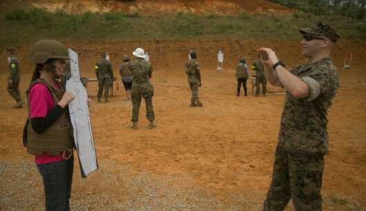 Maj. Kenneth A. McKean takes a photo of his wife and her target during a Jane Wayne event on Camp Schwab, Okinawa, Japan, March 18, 2016. Jane Wayne events are designed to bring families closer together and give family members the opportunity to see what their loved ones do on a daily basis. McKean, from North Ridgeville, Ohio, works in the operations section with Combat Assault Battalion, 3rd Marine Division, III Marine Expeditionary Force. (U.S. Marine Corps photo by Cpl. William Hester/ Released)