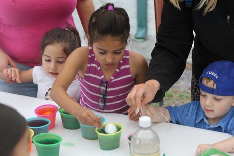 A young child paints an Easter egg during Recruiting Station Orlando’s Easter Family Day March 19, 2016, Lakeland, FL. Children painted eggs the colors they desired with the assistance of their parents. 