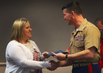 Jenna Kauffman receives her District Spouse Orientation Course completion certificate from Col. Jeffrey Smitherman March 25, 2016, at the Marine Bachelor's Quarters on Beaufort Air Station. The DSOC program is to help spouses establish and connect a support network with other recruiting spouses. In addition, they receive classes on how to strengthen their marriages with their Marines. Kauffman is a spouse from Recruiting Station Nashville, 6th Marine Corps District. Smitherman is the commanding officer of the 6th Marine Corps Recruiting District, Parris Island, South Carolina. (Official Marine Corps photo by Cpl. Diamond N. Peden/Released)