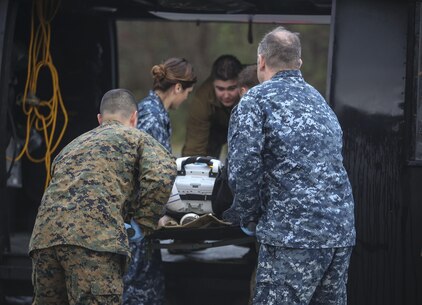 Sailors with 2nd Medical Battalion load a simulated casualty onto a training helicopter during a mass casualty training scenario at Camp Lejeune, N.C., March 25, 2016. The injuries the sailors encountered included simulated gunshot wounds, blast wounds and burns. (U.S. Marine Corps photo by Cpl. Paul S. Martinez/Released)