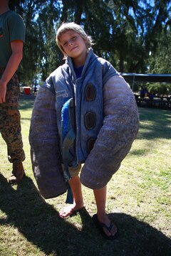 MARINE CORPS TRAINING AREA BELLOWS – Christopher Flurry, a Cub Scout from Pack 311 puts on a dog bite jacket to see how it fits after a Marine military work dog demonstration, March 5, 2016. Marines and civilian officers gave different commands to their dogs, showing off their intelligence and obedience. The dog handlers also wore a bite jacket for a mock take down by the dogs to show the scouts the discipline and training the dogs show when facing a real threat. Christopher, a Flagstaff, Ariz., native said his favorite dog was Diego, the German Shepard because he was the biggest and the fastest of the dogs there. (U.S. Marine Corps Photo by Lance Cpl. Jesus Sepulveda Torres)