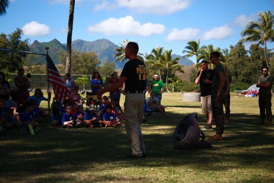MARINE CORPS TRAINING AREA BELLOWS – Marines and civilian officers from the Provost Marshal’s Office Military Working Dogs Unit with Headquarters Battalion from Marine Corps Base Hawaii answer questions and explain the importance of their job to a Cub Scout Troop aboard Marine Corps Training Area Bellows, March 5, 2016. Marines and civilian officers gave different commands to their dogs, showing off their intelligence and obedience. The dog handlers also wore a bite jacket for a mock take down by the dogs to show the scouts the discipline and training the dogs show when facing a real threat. (U.S. Marine Corps Photo by Lance Cpl. Jesus Sepulveda Torres)