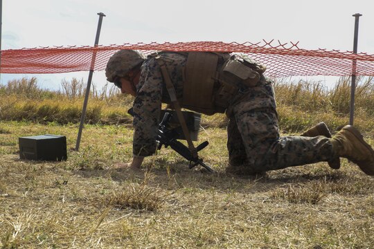 MARINE CORPS BASE HAWAII —  Cpl. Bradley Saunders, an infantry assaultman with Fox Company, 2nd Battalion, 3rd Marine Regiment, and a Platteville, Wis., native, low crawls under netting while carrying ammo cans during the Pacific Combat Shooting Match at the Kaneohe Bay Range Training Facility aboard Marine Corps Base Hawaii, March 16, 2016 Teams from different units used various weapons and tactics to achieve the fastest time possible on different courses of fire, while earning points for awards during the competition. Marines from the Marine Corps Combat Shooting Team instructed and gave advice to the Marines participating in the event. (U.S. Marine Corps Photo by Lance Cpl. Jesus Sepulveda Torres)