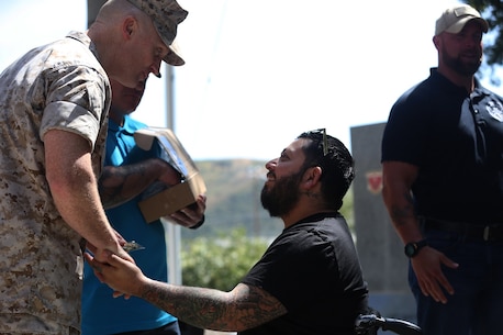 MARINE CORPS BASE CAMP PENDLETON, Calif. – Cpl. Juan Dominguez accepts a challenge coin from Col. Jason Morris at the 3rd Battalion, 5th Marine Regiment “Dark Horse” Reunion at the San Mateo Memorial Garden April 29, 2016. Dominguez served as a rifleman with Company K during the battalion’s deployment to Sangin, Afghanistan in the fall of 2010. (U.S. Marine Corps photo by Lance Cpl. Shellie Hall/Released)