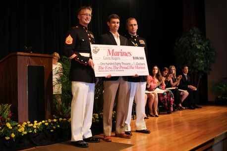 Staff Sgt. Dalton Miller, a canvassing recruiter with Recruiting Station Orlando, and Capt. Kevin Lowe, executive officer for RS Orlando, presents Gavin Rogers, a senior at Steinbrenner High school, the NROTC Marine Option Scholarship during an awards ceremony May 5, 2016. Rogers will be granted the opportunity to serve his country as a Marine officer upon completion of his degree. (Official Marine Corps photo by Sgt. Brian A. Stevens/Released)