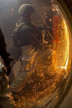 Sgt. Micah Steven McMackins, an aircraft rescue and firefighting specialist with Headquarters and Headquarters Squadron saws through the wall of a simulated aircraft as part of the aircraft salvage and recovery operations during exercise Thunder Horse 16.2 at the Japan Ground Self-Defense Force’s Haramura Maneuver Area in Hiroshima, Japan, May 11, 2016. Motor transportation operators, combat engineers, heavy equipment operators and aircraft rescue and firefighters worked together to recover the simulated downed aircraft. The exercise focuses on reinforcing skills that Marines learned during Marine Combat Training and throughout their military occupational specialty schooling in order to maintain situational readiness. (U.S. Marine Corps photo by Lance Cpl. Aaron Henson/Released)