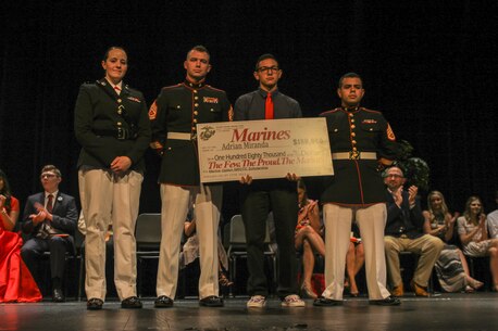 Captain Jennifer Mozzetta, executive officer for Recruiting Station Orlando, Gunnery Sgt. Gregory Hauk, station commander for Recruiting Substation Orlando, and Staff Sgt. Magno Choez, a recruiter for RSS Orlando, award Adrian Miranda, a senior at Boone High School, the NROTC Scholarship during an awards ceremony May 18, 2016, at Boone High School. 