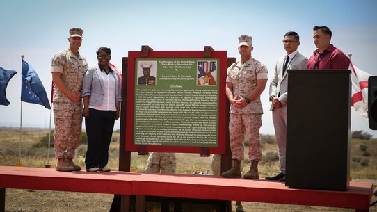 Colonel Christopher Nash, Lora Smith-Merriweather, CWO4 Brett Cordsen, battalion gunner, Weapons and Field Training Battalion, Ian Gilbert and Ricardo Reyes (L to R), stand beside the citation honoring Cpl. Larry Harris at Marine Corps Base Camp Pendleton, Calif., May 19.  An obstacle of the Crucible was named after the Marine, who was killed in action on July 1, 2010.  His citation will be read every iteration of the Crucible, ensuring his heroics and legacy will never be forgotten.