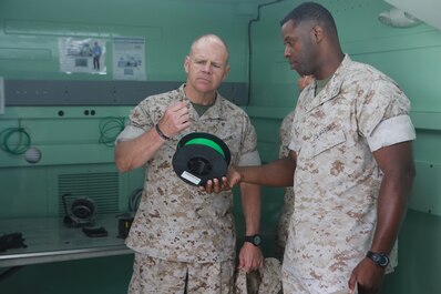 U.S. Marine Corps Lt. Col. Gregory Pace, commanding officer, 1st Maintenance Battalion, Combat Logistics Regiment 15, 1st Marine Logistics Group showed the spools of plastic that are used to create products using the 3D printers in the Expeditionary Manufacturing System with Gen. Robert Neller, Commandant of the Marine Corps on Camp Pendleton, Calif., May 24, 2016. The Expeditionary Manufacturing System is a mobile 3D printing and milling shop designed to provide quick turnaround for mission critical parts in deployed environment. (U.S. Marine Corps photo by Sgt. Rodion Zabolotniy, Combat Camera, Camp Pendleton/RELEASED)