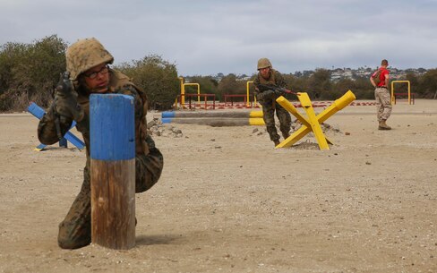 Recruits from Bravo Company, 1st Recruit Training Battalion, provide cover for each other during the Bayonet Assault Course at Marine Corps Recruit Depot San Diego, May 24. Before allowing a team member to advance to the next obstacle, a recruit had to provide cover simulating what it would be like watching another Marine’s back while moving in combat. Annually, more than 17,000 males recruited from the Western Recruiting Region are trained at MCRD San Diego. Bravo Company is scheduled to graduate June 17.