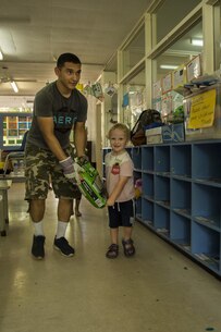 U.S. Marine Lance Cpl. Adrian Lozano helps an Australian preschooler carry potting mix at Millner Preschool, Northern Territory, Australia, on May 28, 2016. U.S. Marines with Forward Coordination Element, Marine Rotational Force – Darwin, volunteered with preschool teachers and parents to clean up the schoolyard for preschoolers. MRF-D is a six-month deployment of Marines into Darwin, Australia, where they will contribute to and engage with local communities. Lozano, from Los Angeles, California, is an administration specialist with FCE, MRF-D.