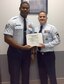 Senior Master Sgt. Brian Dixon, 331st Recruiting Squadron production superintendent, presents Staff Sgt. Zachariah Earle, 331st Recruiting Squadron enlisted accessions recruiter, with recruiting certification, Oct. 21.