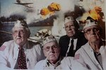 A photo of Bob McKenney (left), Richard Schimmel (center bottom), and two other Pearl Harbor survivors hangs in Schimmel’s home office. 
